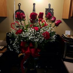 Bland's Florist - A dozen roses with carnations and baby's breath.