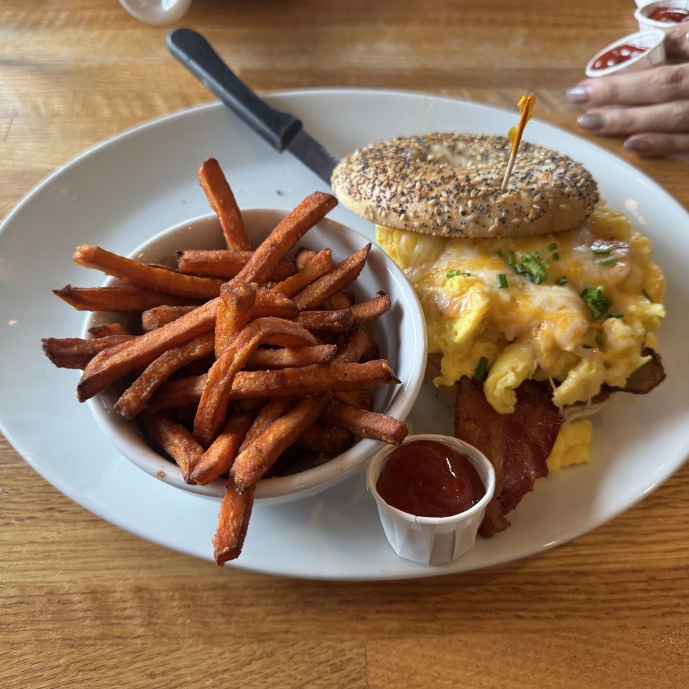 Bacon egg and cheese bagel sandwich with sweet potato fries Bacon egg and cheese bagel sandwich with sweet potato fries