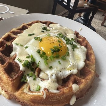 Shirt Factory - Bacon & cheddar savory waffle (house made bacon, cheddar, herb waffle with a sunny side up egg, house cheesy béchamel & green onion) - Sandwiches Near Me - Medina, New York