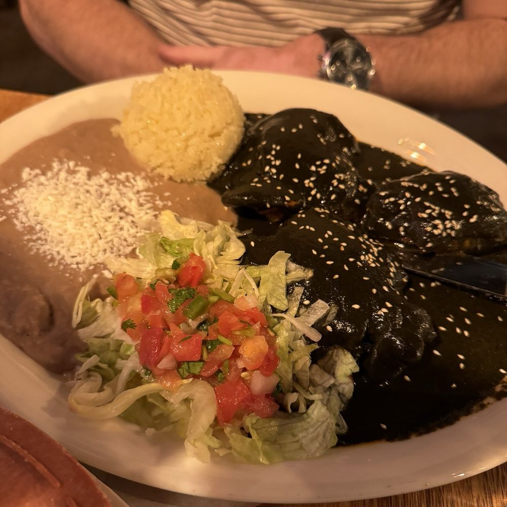 La Doña Mezcaleria - Mole Oaxaca on top of slow cooked chicken thighs. Served with rice and beans. - Mexican Near Me - Denver, Colorado La Doña Mezcaleria - Mole Oaxaca on top of slow cooked chicken thighs. Served with rice and beans. - Mexican Near Me - Denver, Colorado