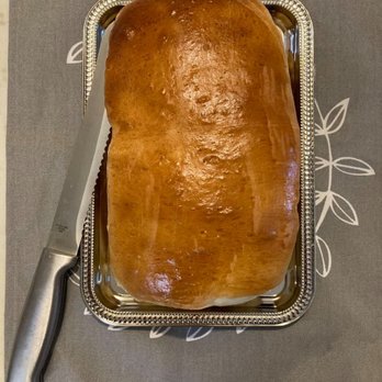 Tammie's Bread - a loaf of bread on a tray with a knife - Bakeries Near Me Tammie's Bread - a loaf of bread on a tray with a knife - Bakeries Near Me