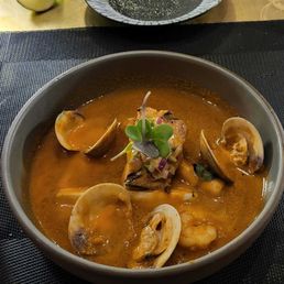 "A circle of clams and shrimp." One shrimp. Tiny overcooked piece of fish.