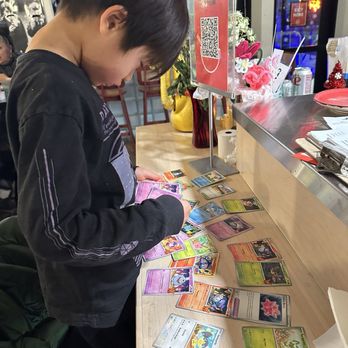 Staff Meeting - Our older son picking out a Pokemon card to bring home from the chef - Asian Fusion Near Me - Minneapolis, Minnesota
