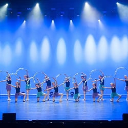 Ndigo - Dansers reiken opzij met fleurige hoepels in hun handen