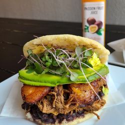 Heaven Restaurant Market - Our most popular, 
 Pabellon Arepa , it has layers of  black beans, shredded beef, sweet fried plantain, avocados and micro greens .