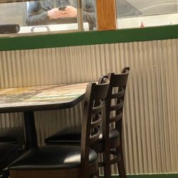 Wingstop - Employee, who states he is the manager, on his phone, in between placing food in paper trays, and placing food in bags for customers.