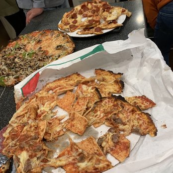 Pierri Pizza - Three pizzas are shown on a kitchen counter, including a pepperoni pizza, a vegetable pizza, and a partially eaten pizza with mushrooms and sausage. - Pizza Near Me - Appleton, Wisconsin