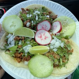 Three tacos -- carnitas, Al pastor, and chorizo Three tacos -- carnitas, Al pastor, and chorizo