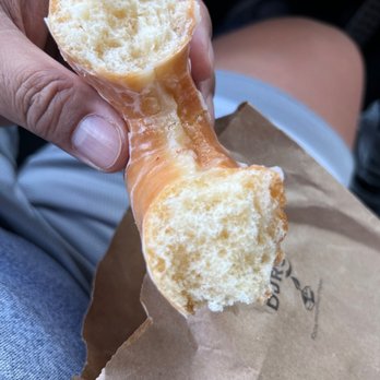 D&E Donuts - a person holding a half eaten donut - Donuts Near Me - Clearwater, Florida