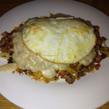The Scrambler House - Hot Mess- Crispy home fries topped with ham, bacon, sausage, mushrooms, onions, tomatoes, cheddar, sausage gravy and 2 eggs on top. - American Near Me - O'Fallon, Missouri The Scrambler House - Hot Mess- Crispy home fries topped with ham, bacon, sausage, mushrooms, onions, tomatoes, cheddar, sausage gravy and 2 eggs on top. - American Near Me - O'Fallon, Missouri