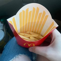 a person holding a basket of french fries