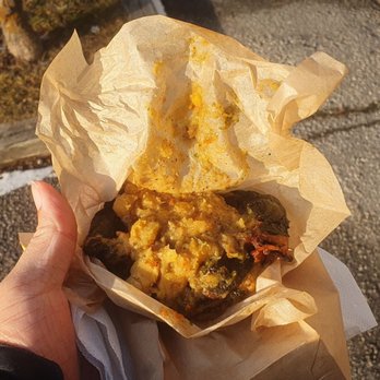 ACR Hot Roti & Doubles - a person holding a hot dog - Caribbean Near Me - Scarborough, Ontario