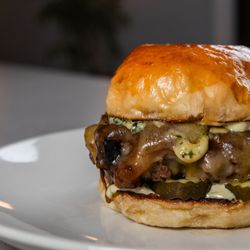 Native Fields - Grass-Fed Beef Burger, we make our buns in house, with caramelized onions, gruyere cheese, aioli and pickles.  Lunch and Dinner