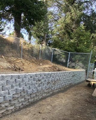 Retaining Walls - Strengthen your landscape and prevent soil erosion with our custom retaining walls. Our retaining walls are built to last, using high-quality materials such as concrete, stone, and timber to create structures that are both functional and visually appealing. Ideal for managing slopes, creating garden beds, or adding usable space to your yard, our retaining walls are tailored to fit your specific landscape needs. We handle everything from design to installation, ensuring that each wall is constructed with the utmost care and precision. Enhance the beauty and stability of your outdoor space with retaining walls that are as practical as they are attractive.