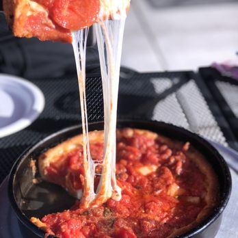 Johnny Mo's Pizzeria - a piece of pizza being lifted by a spatula - Pizza Near Me - Seattle, Washington