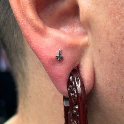 Piercing by Coco Stabs - Cross lobe piercing.