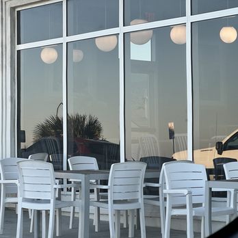 Faro - a table and chairs outside of a restaurant - Pizza Near Me - Flagler Beach, Florida