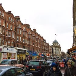Tesco - Queensway Rd is a busy street with shopping, restaurants of many varieties, and markets.