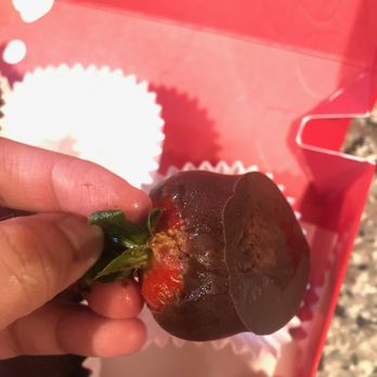 Edible Arrangements - a hand holding a chocolate covered strawberry - Gift Shops Near Me - Clarksville, Tennessee