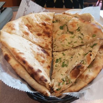 Masala - Naan Sampler - A basket containing two types of naan bread, one plain and one topped with herbs, served on a paper liner at a restaurant. - Pakistani Near Me - West Warwick, Rhode Island