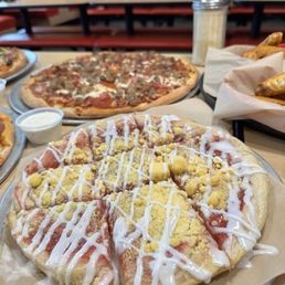 a variety of pizzas on a table a variety of pizzas on a table