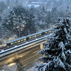 SkyTrain - Early-morning (before 7 am) snowy views today from our apartment balcony, of skytrains approaching Lougheed Station.