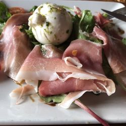 . Prosciutto (jambon cru) freshly cut & served atop vinaigretted mesclun with fresh mozzarella.
