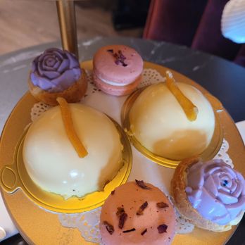 FogRose Atelier - Dessert tier: lychee rose macarons, blueberry lavender cream puffs, and mango mousse domes with chocolate cake base. - Desserts Near Me - Kirkland, Washington FogRose Atelier - Dessert tier: lychee rose macarons, blueberry lavender cream puffs, and mango mousse domes with chocolate cake base. - Desserts Near Me - Kirkland, Washington
