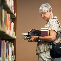 Rapid City Public Library - Lady browsing materials in our nonfiction section.
