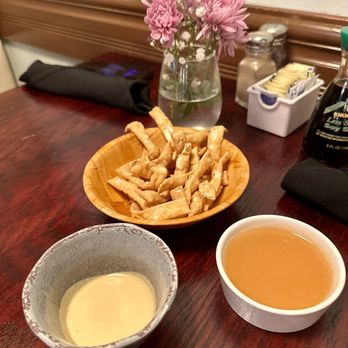 Red Ginger Suntree - a table with a bowl of sauce, a bowl of crackers, and a plate of crackers - Cocktail Bars Near Me - Melbourne, Florida Red Ginger Suntree - a table with a bowl of sauce, a bowl of crackers, and a plate of crackers - Cocktail Bars Near Me - Melbourne, Florida