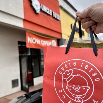 Uncle Tetsu - a hand holding a red shopping bag - Bakeries Near Me - San Diego, California