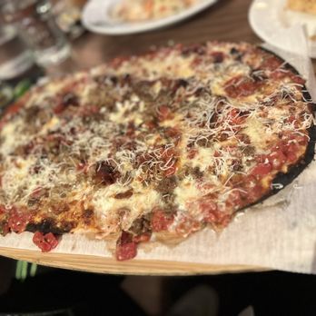 Felice 56 - a pizza on a wooden cutting board - Italian Near Me - New York, New York