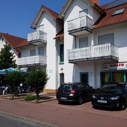 Rialto - Restaurant-Front - Rechts Parkplätze, Links Tische und Stühle.