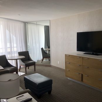 The Wayfarer San Diego - Sleeper sofa, 2 tables & chairs, 1 of the 2 TV's and 1 of the 2 balconies. Room 214, ocean front 2 queen suite. - San Diego, CA