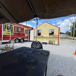 Lorenzo’s Tacos & Burritos - Outside of the taco truck. They've got a couple tables and eight seats under an awning.
