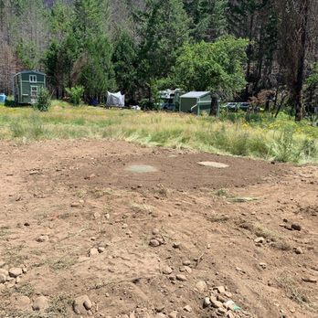 Best Septic Tank Pumping - Nice job with the replacement septic system. - A dirt clearing in a backyard with trees, a small shed, and outdoor items visible in the background, indicating land preparation. - Septic Services Near Me - Eugene, Oregon