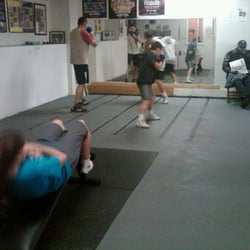 Chicago Youth Boxing Club - Three young men shadowbox while another member gets in her sit-ups for the day.