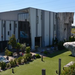 High Moves - Außenansicht der Halle mit Niederseilgarten und Boulderblock im Vordergrund