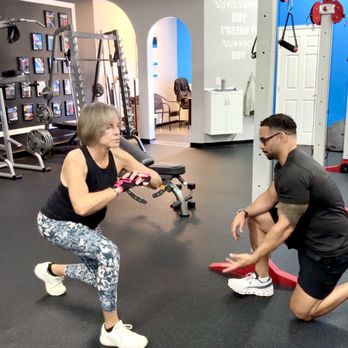 Trinity Fitness - 1-on1 Personal training studio session located in Palm Beach Gardens Florida. Trainer CC Matthews helping elderly client with proper form. - Gyms Near Me - Palm Beach Gardens, Florida Trinity Fitness - 1-on1 Personal training studio session located in Palm Beach Gardens Florida. Trainer CC Matthews helping elderly client with proper form. - Gyms Near Me - Palm Beach Gardens, Florida