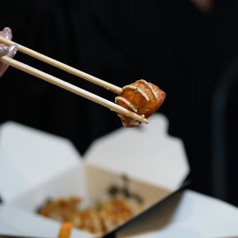 Hoki Poke - a person holding chopsticks over a plate of food - Poke Near Me - Toronto, Ontario Hoki Poke - a person holding chopsticks over a plate of food - Poke Near Me - Toronto, Ontario
