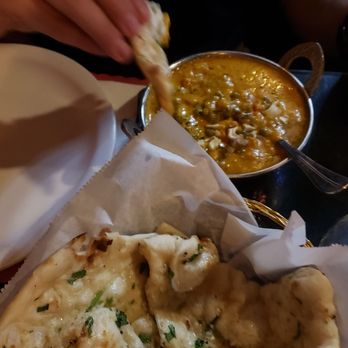Zayka Indian Cuisine - a person taking a slice of bread - Indian Near Me - Springfield, Missouri Zayka Indian Cuisine - a person taking a slice of bread - Indian Near Me - Springfield, Missouri