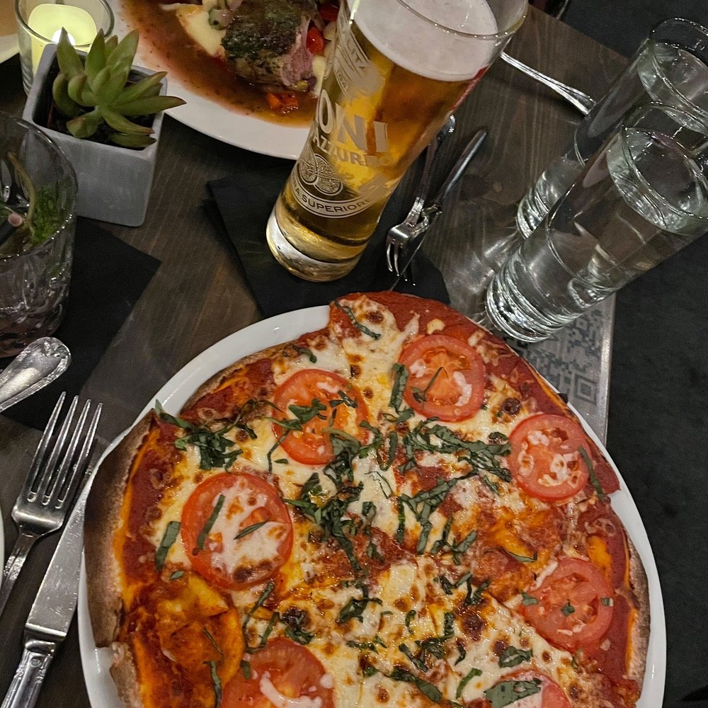 V's restaurant + bar - Margherita pizza & lamb chops in the background. - Italian Near Me - Malibu, California V's restaurant + bar - Margherita pizza & lamb chops in the background. - Italian Near Me - Malibu, California