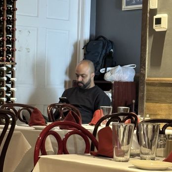 Casarecce - Server on his phone in the dining room - Italian Near Me - Boston, Massachusetts