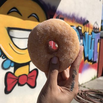 Happy Donuts - Cinnamon sugar donut in front of the cute mural out front. - Donuts Near Me - Oakland, California