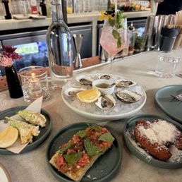 Oysters, squash blossoms, heirloom tomato focaccia, Suppli - all happy hour items Oysters, squash blossoms, heirloom tomato focaccia, Suppli - all happy hour items