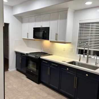 Connecting Remodeling - a kitchen with white cabinets and black appliances - General Contractors Near Me - Los Angeles, California Connecting Remodeling - a kitchen with white cabinets and black appliances - General Contractors Near Me - Los Angeles, California
