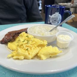 Lofty Pursuits 2-egg breakfast, including scrambled eggs, two thick cut strips of bacon and grits Lofty Pursuits 2-egg breakfast, including scrambled eggs, two thick cut strips of bacon and grits