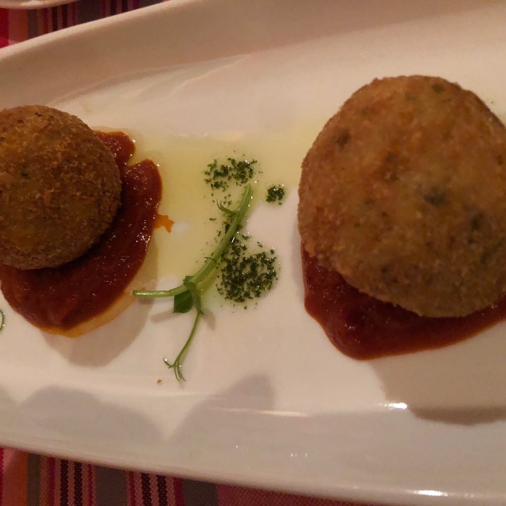Arancini. This appetizer is a must! Fried mushroom goat cheese rice ball on a tomato reduction drizzled in truffle oil. Arancini. This appetizer is a must! Fried mushroom goat cheese rice ball on a tomato reduction drizzled in truffle oil.