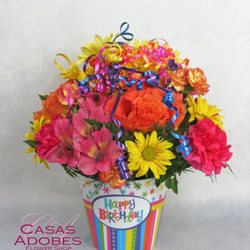 Celebrate the occasion with bright birthday flowers and festive streamers.
