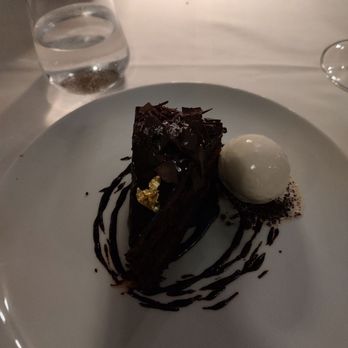 Delmonico's - Chocolate cake with cassis and gold foil frosting with a scoop of vanilla. - Steakhouses Near Me - New York, New York